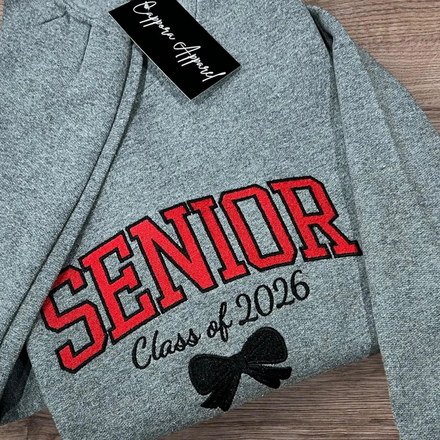 Celebrate graduation in style with our embroidered Senior Class of [Year] Gildan crewneck. Cozy fleece, custom embroidery, and perfect senior gift apparel!